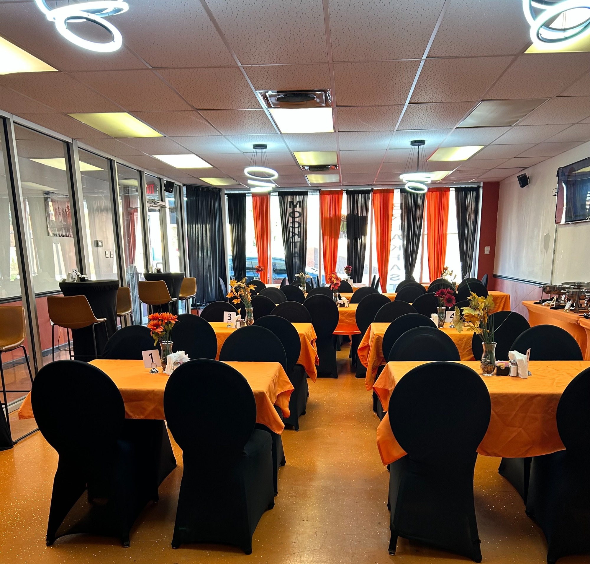 Inside Phamilyden, with black chairs and orange table settings